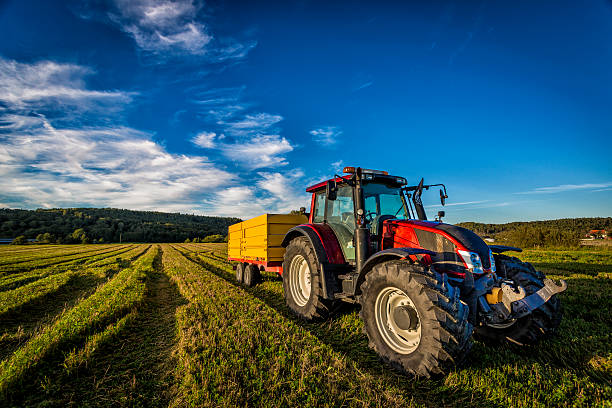 Red tractor with a yellow trailer photographed up close